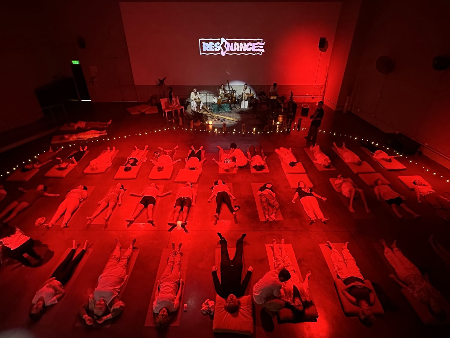 Sesión de sound healing con música en vivo y público recostado — Hotel Wellness de Resonance